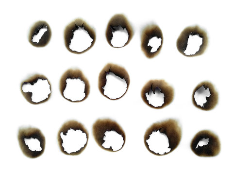 Collection of burnt holes in a piece of paper isolated on white background. Fire holes in white paper.