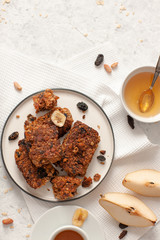 Breakfast with granola, tea and fruit on white wooden background top view mock up.