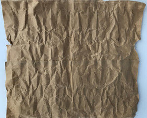 top view shot of light brown crumpled paper on white background