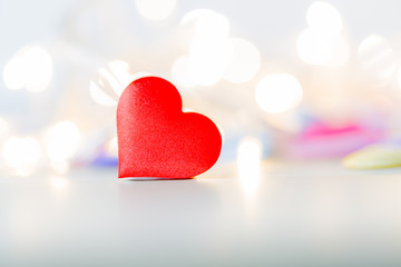 Red heart shape on wood table with soft bokeh