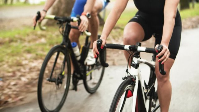 Cropped shot of athletes riding bicycles. Group of sporty people in sportswear cycling on bikes during competition, partial view. Sport concept