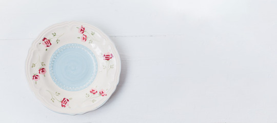 Naklejka premium Vintage tea-ware pale blue color on white table. Tea pot and cup with painted roses