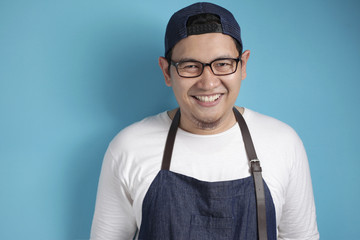 Portrait of happy smiling Asian chef or waiter, good restaurant business concept