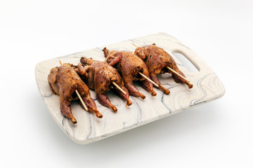 Fresh quail carcasses before cooking on a white background