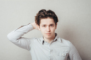 Portrait of a confused male individual with hand in hair