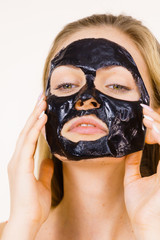 Girl with dried peel-off black mask on face