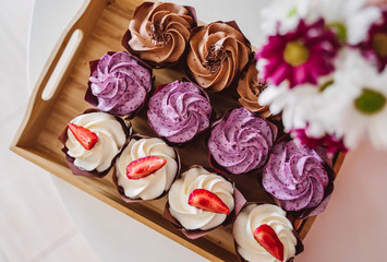 cupcakes on tray next to flowers