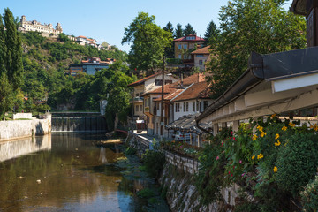 The view of the river Milavitsa, houses and flowers on the shore in the summer in Sarajevo, Bosnia and Herzegovina