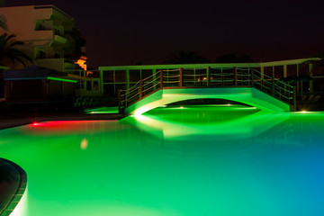 Hotel night swimming pool with a bridge and beautiful lighting