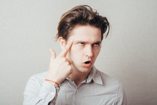 young guy thinks his finger to his temple