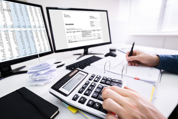 Young Businessman Calculating Bill In Office