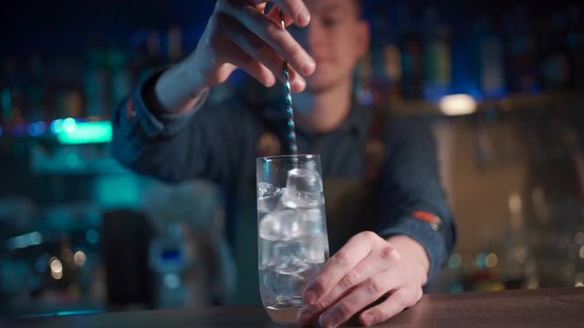 bartender mixing modern gin tonic cocktail with ice