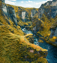 Obraz premium View from flying drone of Fjadrargljufur canyon and river. Magnificent autumn scene of South east Iceland, Europe. Beauty of nature concept background.