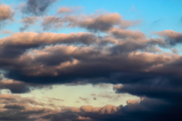Naklejka na ściany i meble Wolken orange, violett, in Nachmittagsstimmung, Abendstimmung vor hellblauem Himmel, Hintergrund