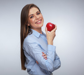 Smiling woman in blue shirt holding red apple.