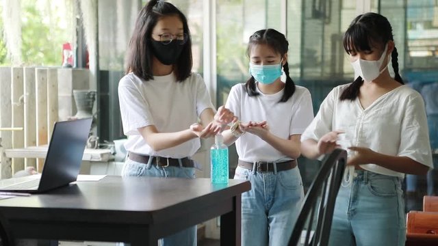 asian teeanger wearing protection mask and taking  hand gel cleaning 