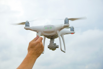 Male hand holds a working quadrocopter