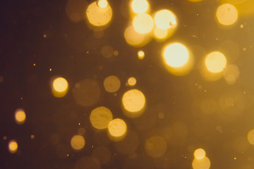 Dark Abstract Gold bokeh sparkle on black background