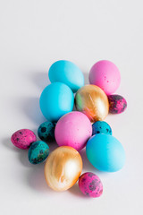 Happy easter concept. Big small eggs of various fashionable colors lie in a heap on a white background. Copy space