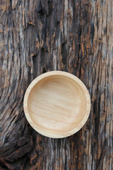 Wooden bowl on wooden background.