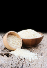 Thai jasmine rices in wooden bowl on wooden background.