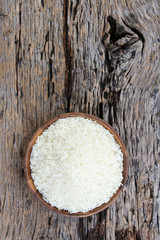 Thai jasmine rices in wooden bowl on wooden background.