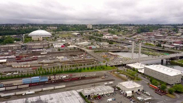 Scenic View Of Vehicles Travelling On The Cable Bridge Over Thea Foss Waterway In Tacoma, Washington With The Famous Tacoma Dome In A Distance - Aerial Shot