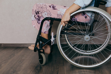 Unrecognizable disabled woman in wheelchair at home. Recovery and healthcare concepts.