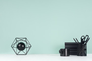Spring workplace with black stationery, stack of books, coffee cup, abstract atom model, pencils in...