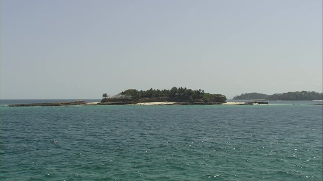 Overflight over a small virgin island with many palm trees and sandy beach in the Las Perlas Archipelago of Panama in the Pacific Ocean