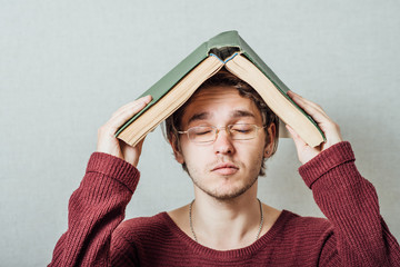 college student standing with book on his head