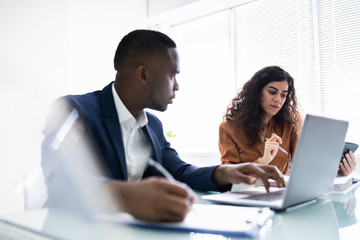Two Businesspeople Calculating Invoice