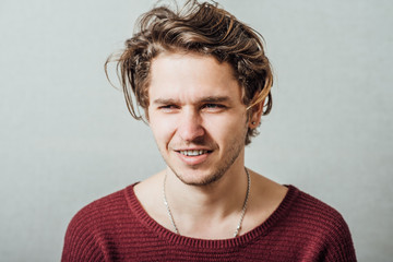 Fototapeta premium Closeup portrait of a happy young man smiling on gray background