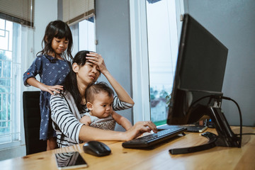 Fototapeta na wymiar stress mother while working from home and babysitting her children
