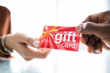 Two Businesspeople Hand Holding Red Gift Card