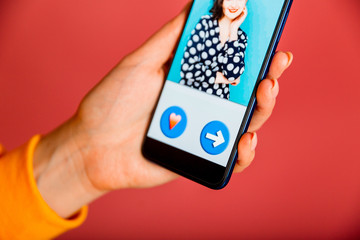 Online dating app in smartphone. Person swiping and liking profiles on relationship site or application. Single guy searching for love partner.
