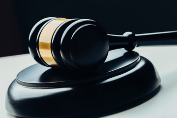 Judge's gavel with gold metal on a black table. Concept of law