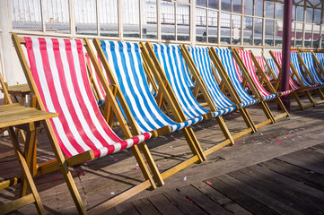 A row of deck chairs in the sun on a  pier