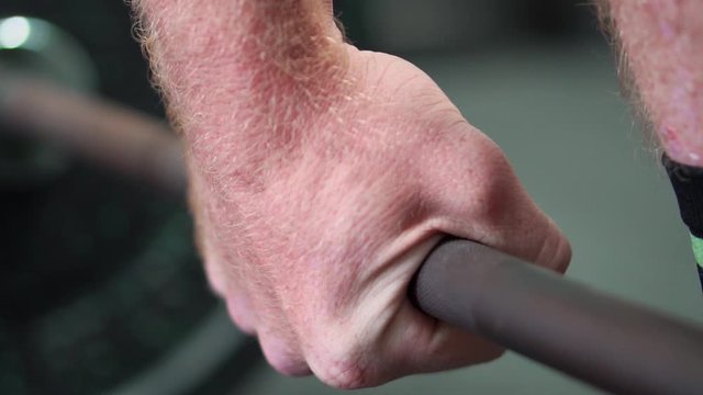 athlete hands grabbing barbell before heavy lift slow motion