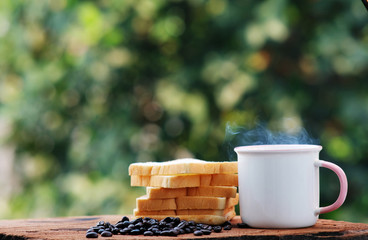 cup of coffee and bread on wood counter background and space for text