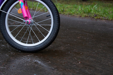 new children's bike in the park and in the rain on a wet road