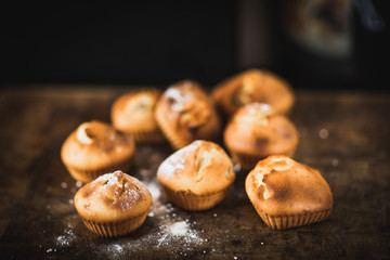 Freshly baked muffins with raisins and dried apricots, shot on a dark background. Background for baking and cooking.