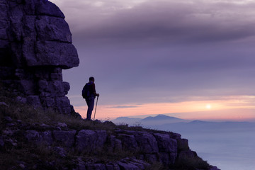 hiker on mountain peak at sunset