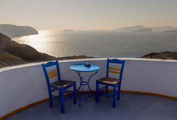 chairs and table on a terrace in santorini