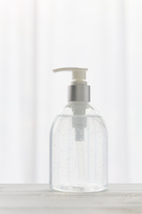 Hand sanitizer bottle or alcohol gel on white wood background for Coronavirus disease (COVID-19) prevention.