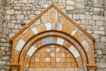 Ancient stone incorporated into medieval facade in Krk town, Croatia