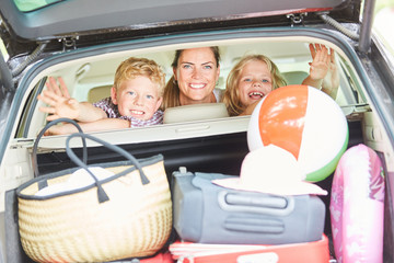 Mutter und Kinder im Auto mit viel Gepäck