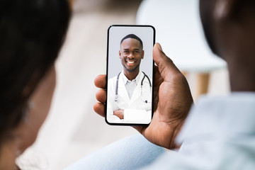 Couple Videoconferencing With Doctor On Mobile Phone
