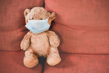 teddy bear wear a surgical mask. Concept of child health care and global pandemic crisis