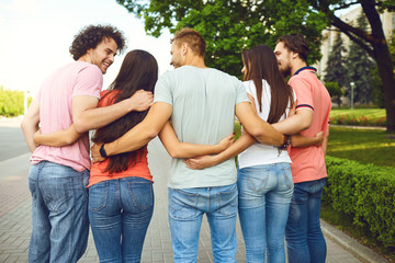 Group of people embrace on a city street in summer.